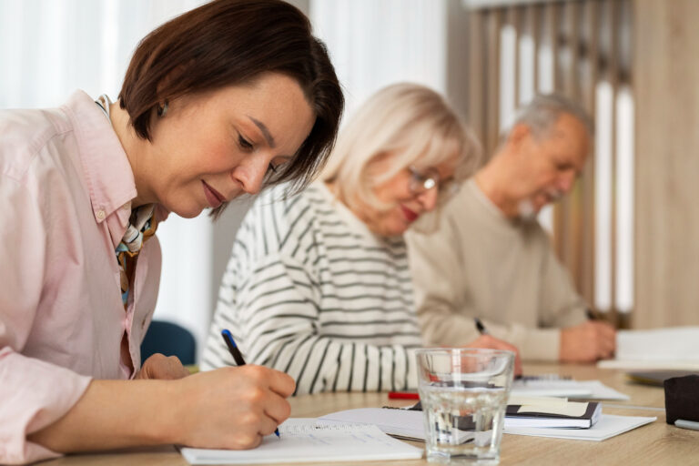 Varias personas de mediana edad estudiando en una mesa - Aloha Vera