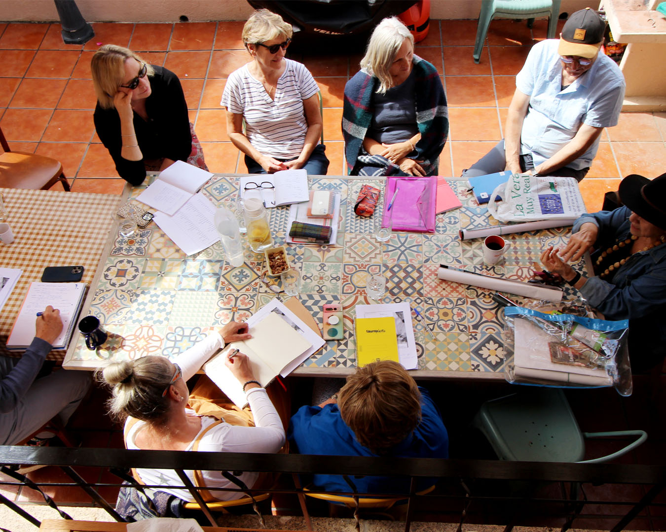 Group meeting around patterned table with notebooks