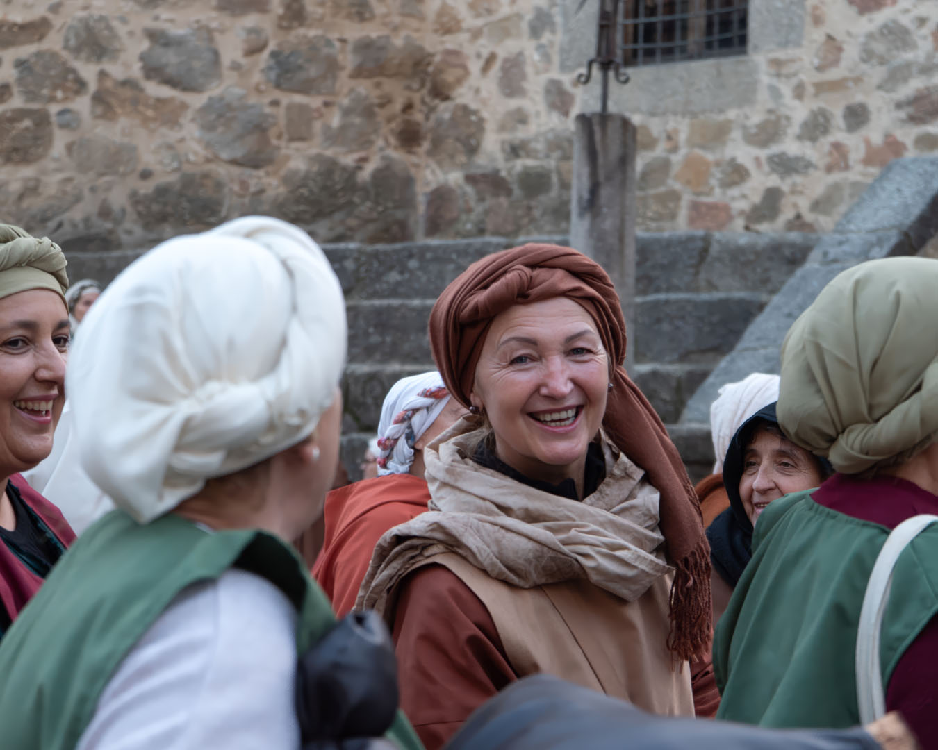 Women in historical dress smiling outdoors