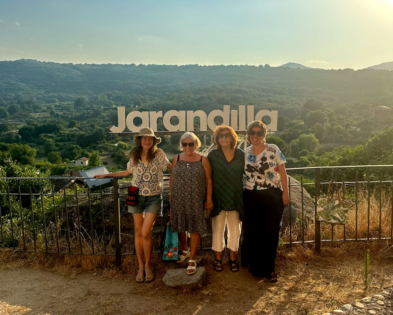 Four women posing before Jarandilla scenic overlook sign