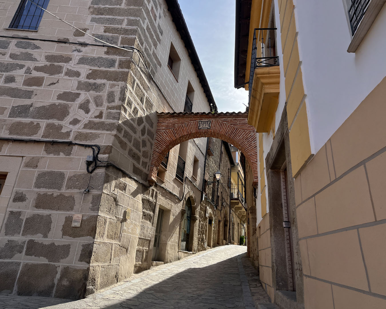 Narrow cobblestone street with brick archway overhead