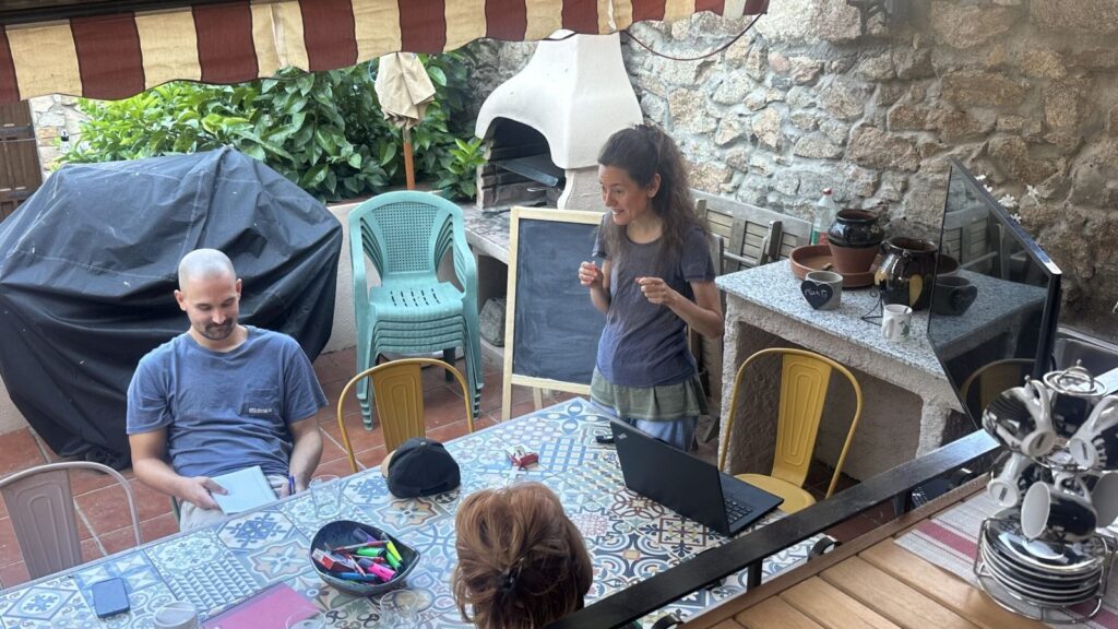 Teacher at a small chalkboard during a Spanish class in the patio