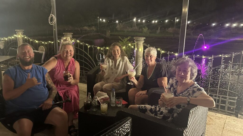 Students enjoying a drink on a terrace at night