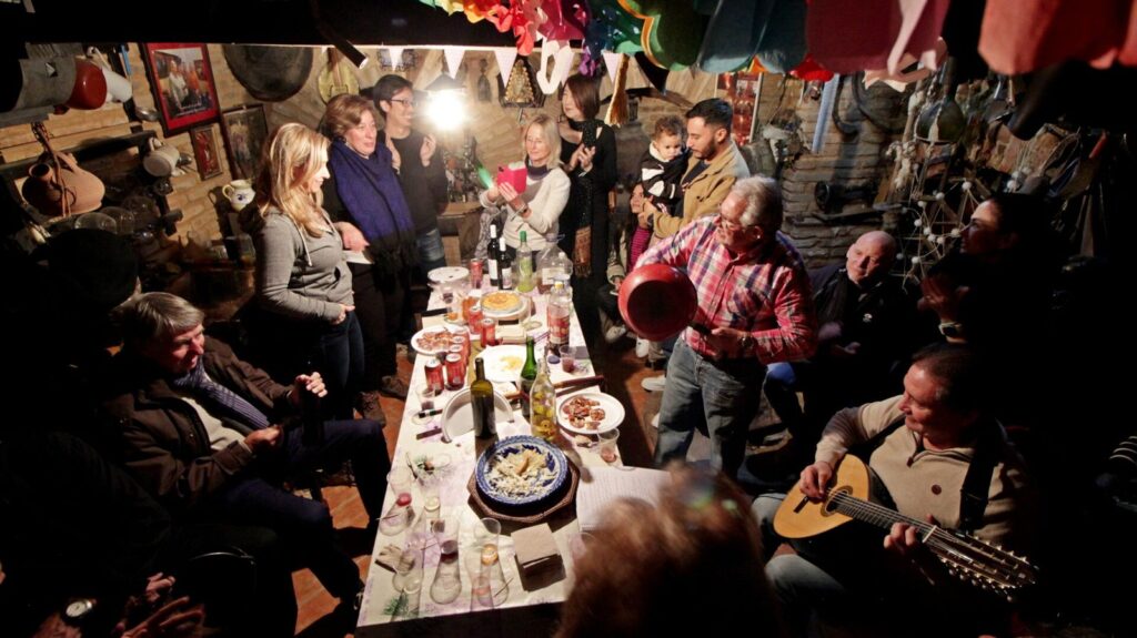 Soirée de musique avec des guitares à une longue table dans une taverne locale