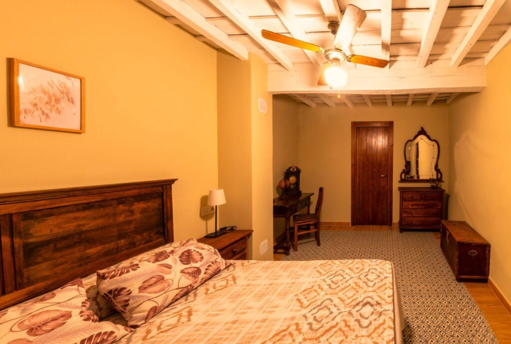 Double bedroom with a wooden headboard and a ceiling fan