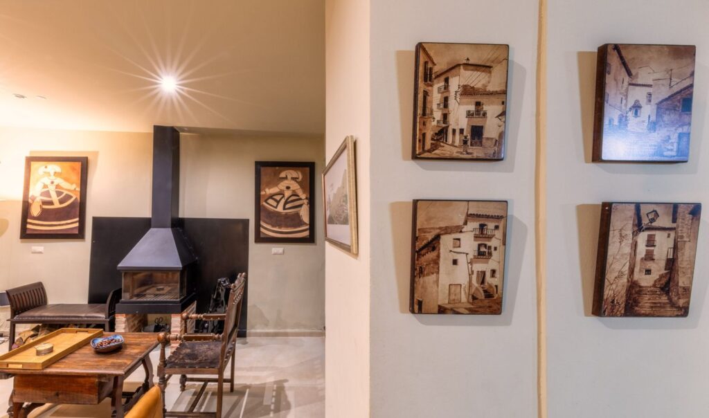 Sitting area with a stove and photos of village streets on the walls