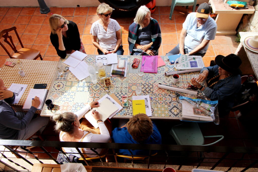 Spanish class around a tiled table in the patio of the Aloha Vera house