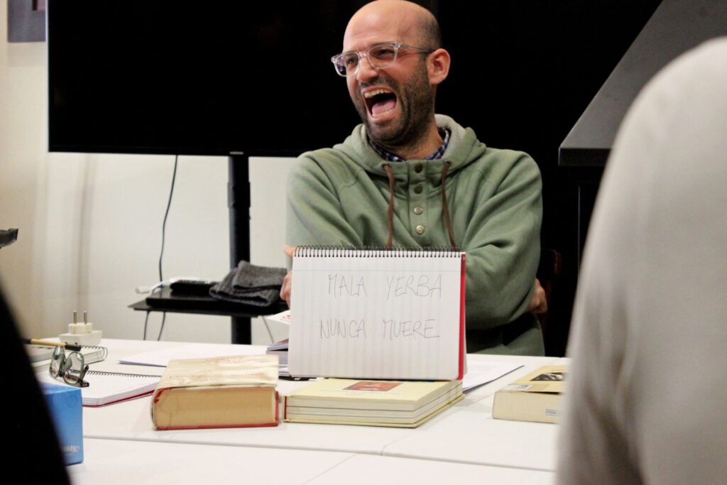 Professeur de rire tenant un cahier avec un message manuscrit