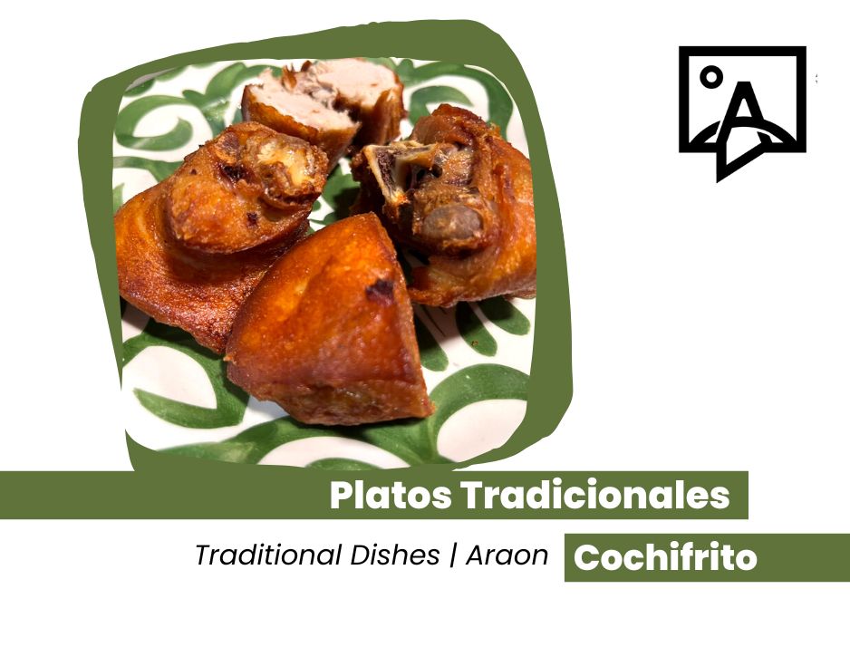 Plats traditionnels: morceaux de cochifrito frits sur une assiette verte et blanche